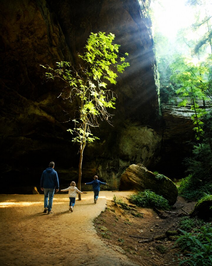 Children running under Ash Cave in the sun