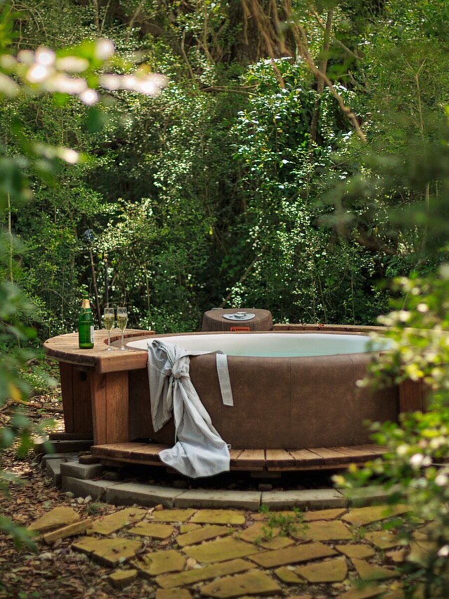 A wooden hot tub outside a cabin